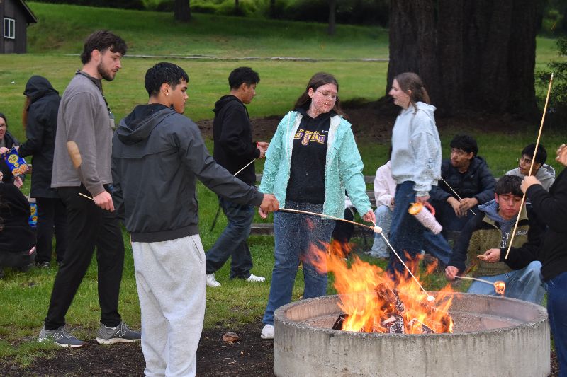 A group of youth health advocates roasting marshmellows.